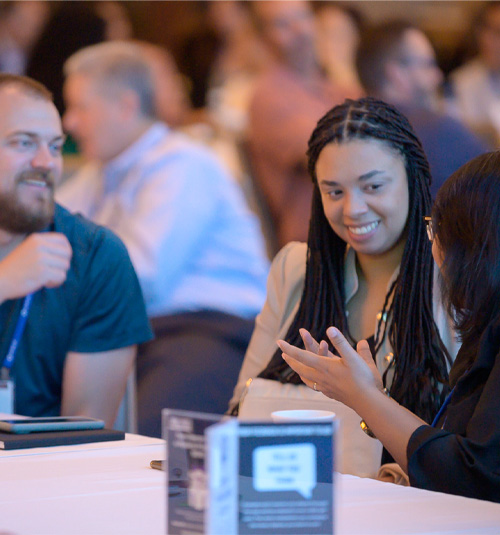 A group of people at the 2024 APQC conference having a discussion. 